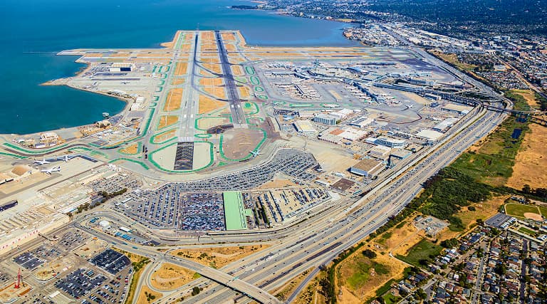An aerial view of a large airport, with runways, terminals, and supporting infrastructure clearly visible.