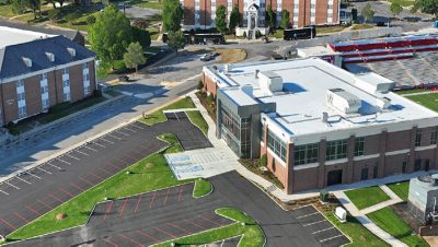 A 3D model featuring buildings and an adjacent parking area